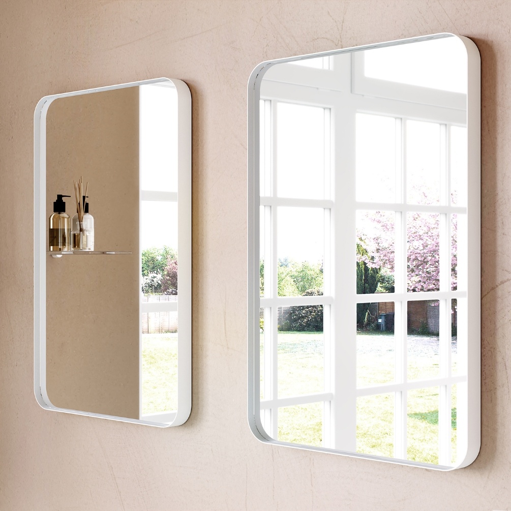 Product Lifestyle image of two Origins Living City Rectangular 500mm x 750mm White Mirror mounted side-by-side on a neutral coloured wall, reflecting an outside view. B375639
